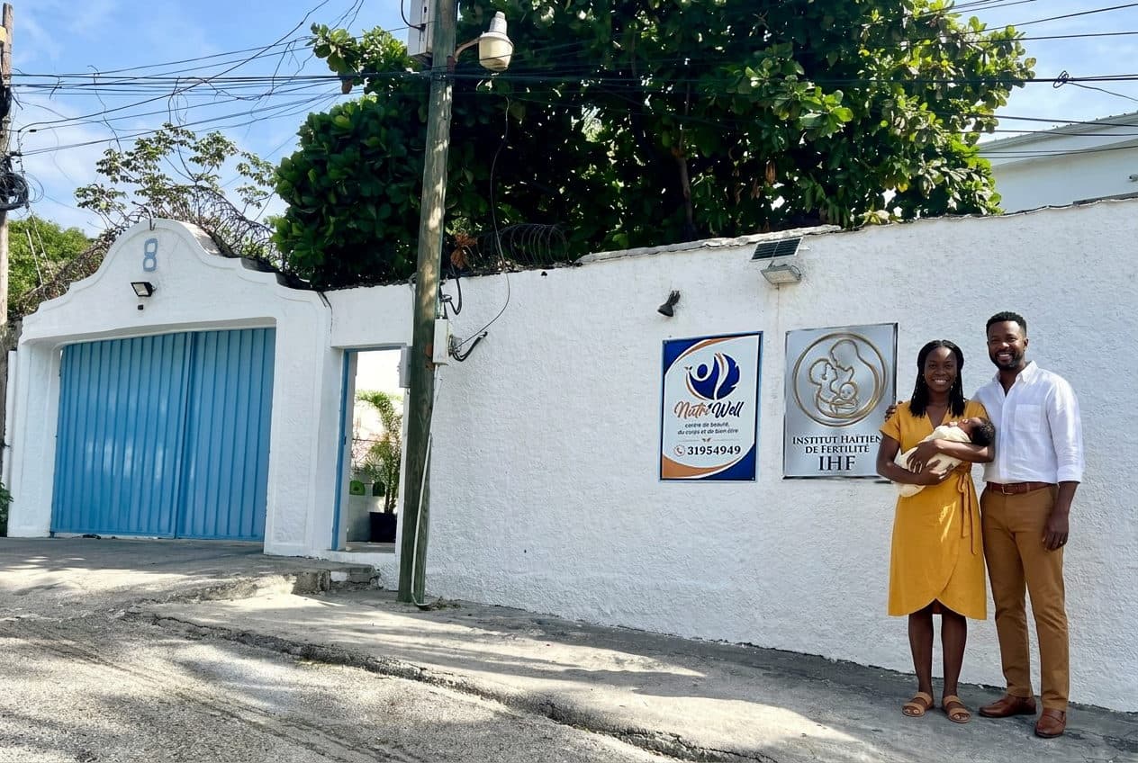 Le couple pose avec son nouveau-né devant la plaque de l'Institut