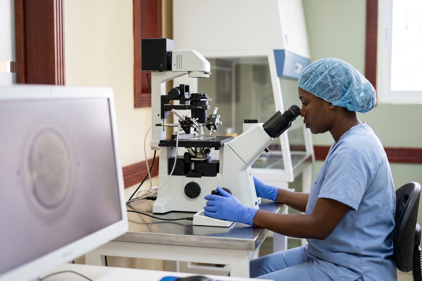 Embryologiste au microscope pendant une micro-injection ICSI